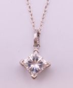 A princess cut diamond pendant on a silver chain. Diamond spreading to approximately 1 carat.