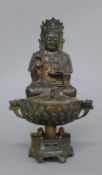 A bronze model of Buddha mounted on a stand. 23 cm high.