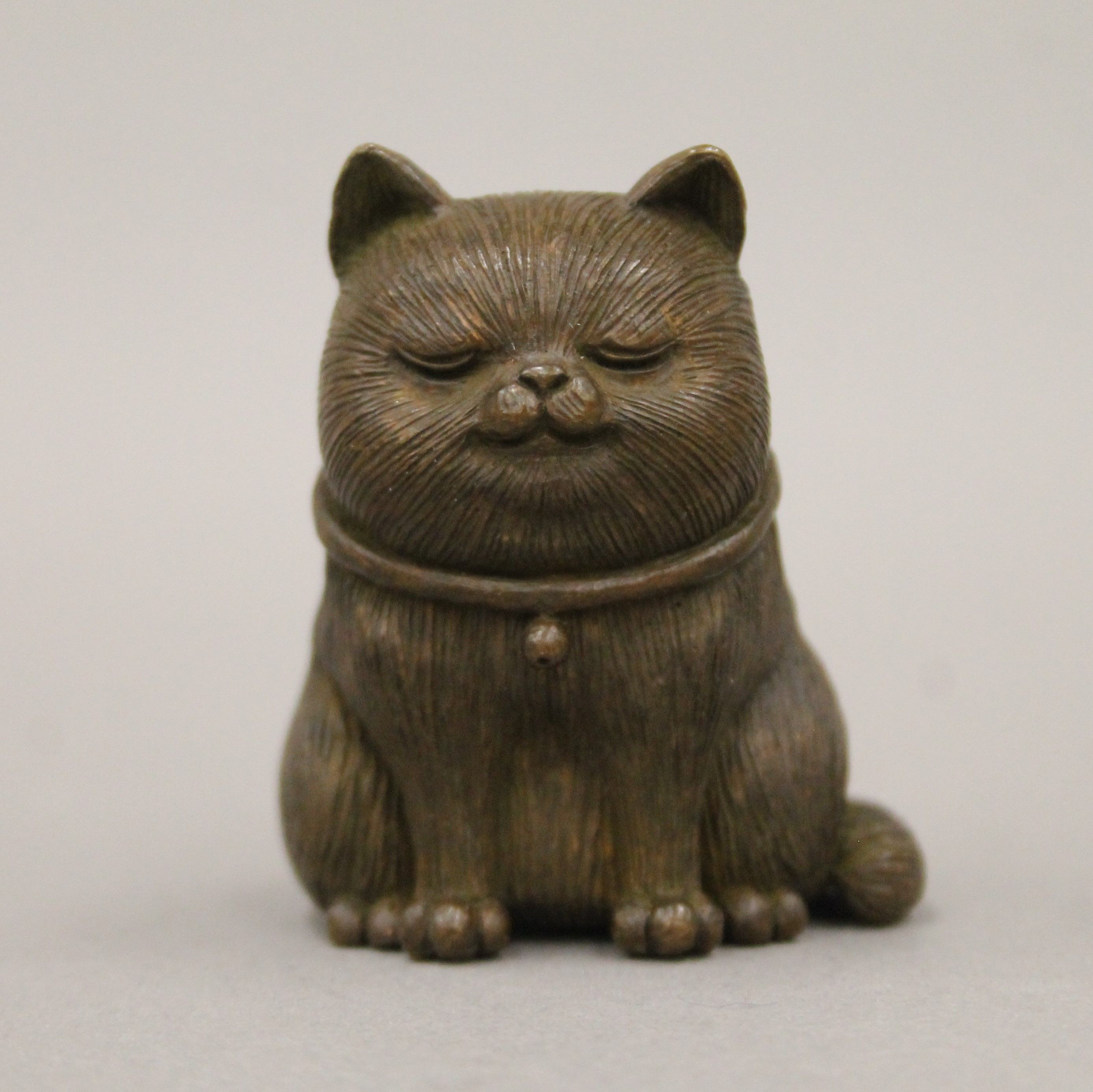 A bronze model of a cat. 5.5 cm high.