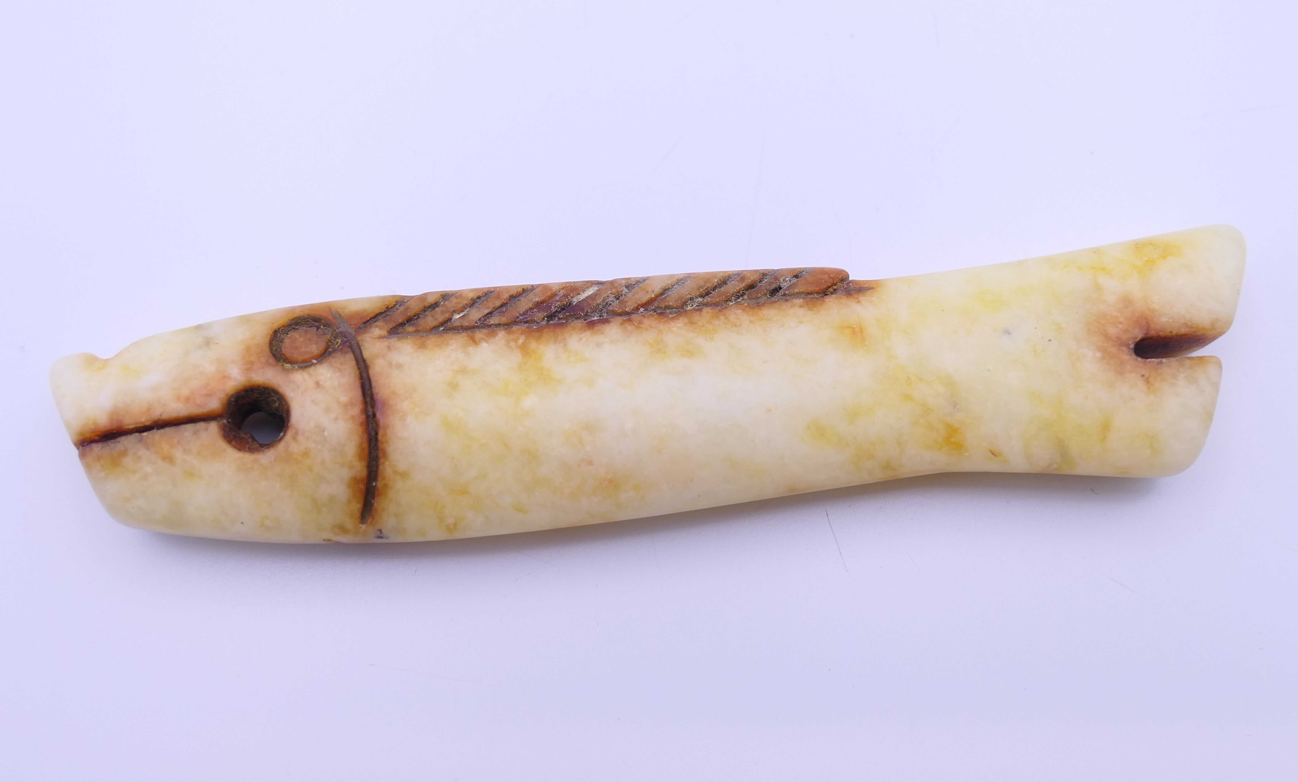 A small Chinese russet jade coloured fish, Shang Dynasty. 7.5 cm long.