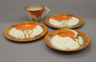 A Clarice Cliff cup, saucer and two plates. The cups 6 cm high.