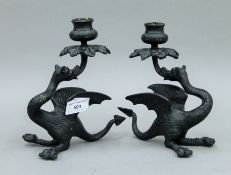 A pair of patinated bronze dragon form candlesticks. 19 cm high.