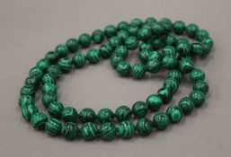 A string of malachite beads. Approximately 87 cm long.