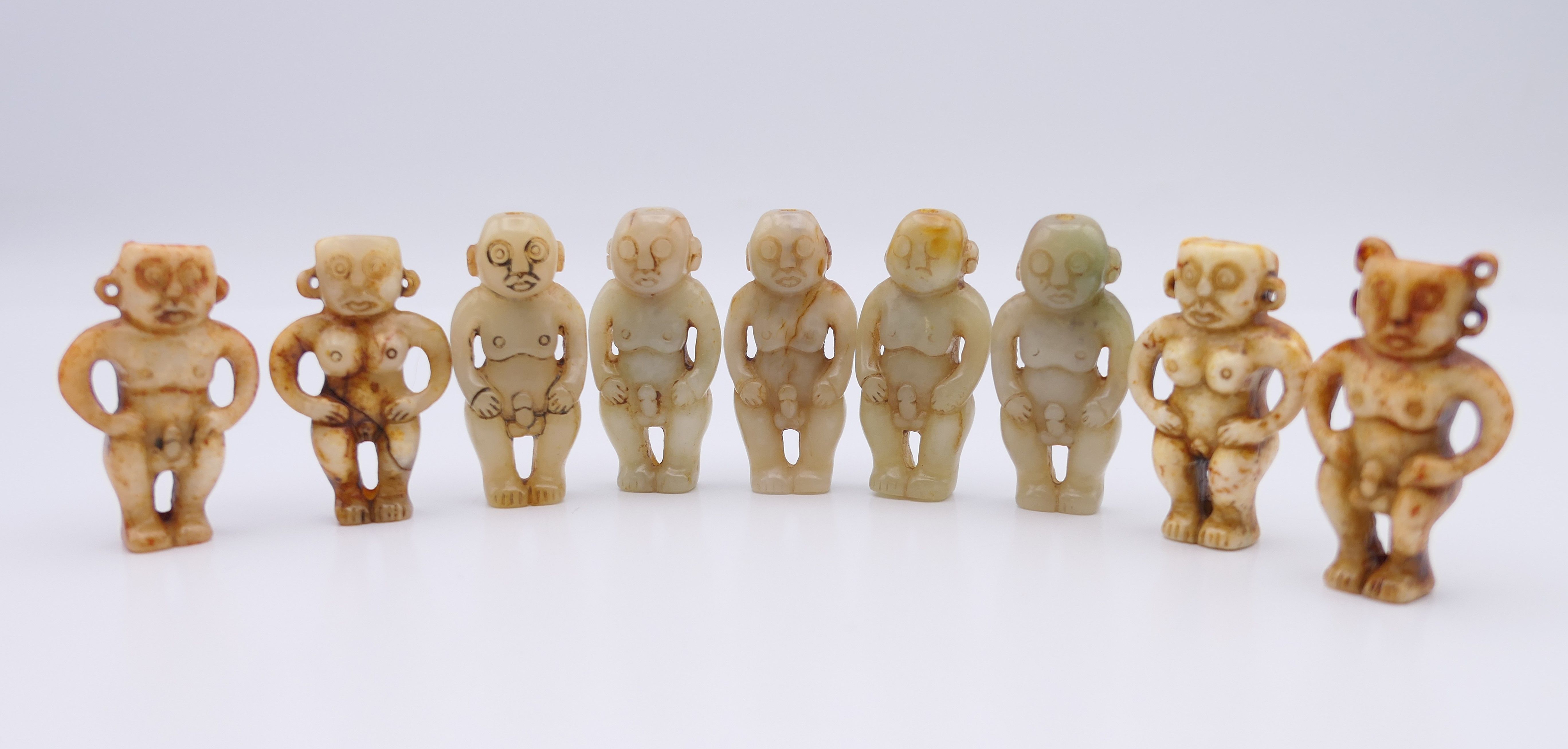 Nine Chinese fertility beads (seven male and two female), Han Dynasty. Each approximately 4 cm high.