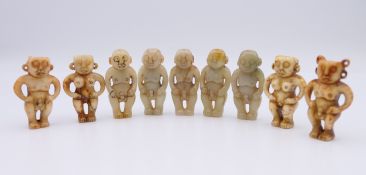 Nine Chinese fertility beads (seven male and two female), Han Dynasty. Each approximately 4 cm high.