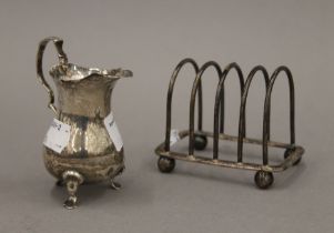 A small silver cream jug and a silver toast rack. The former 8.5 cm high. 165.6 grammes.