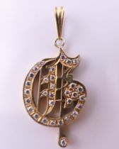 A 14 ct gold diamond set musical note pendant. 2.5 cm high excluding suspension loop. 4.