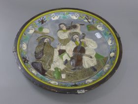 A 19th century Continental pottery plaque depicting figures playing musical instruments.
