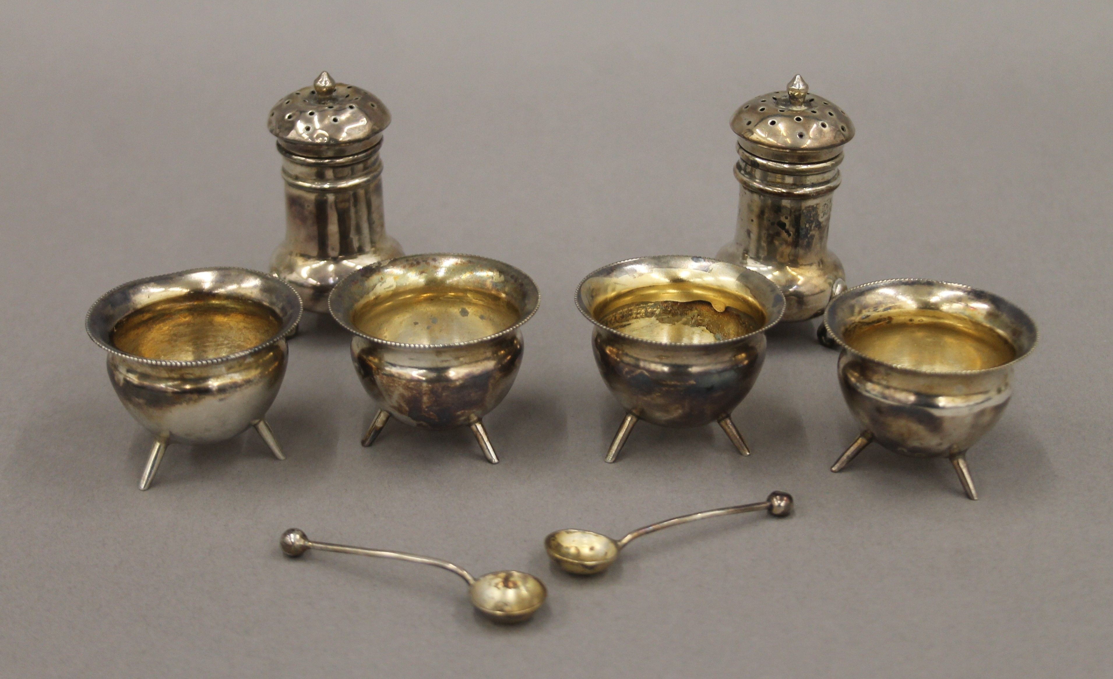 Four silver salts, two silver salt spoons and two silver peppers. The peppers 5.5 cm high. 107.