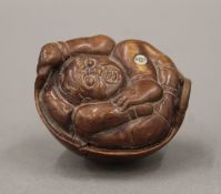 An Oriental model of a man in a basket. 5 cm long.