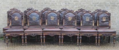 A set of twelve Victorian parcel gilt and carved walnut dining chairs with leather seats with