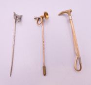 Two stick pins formed as a fox mask and a horn, and a brooch formed as riding crop.