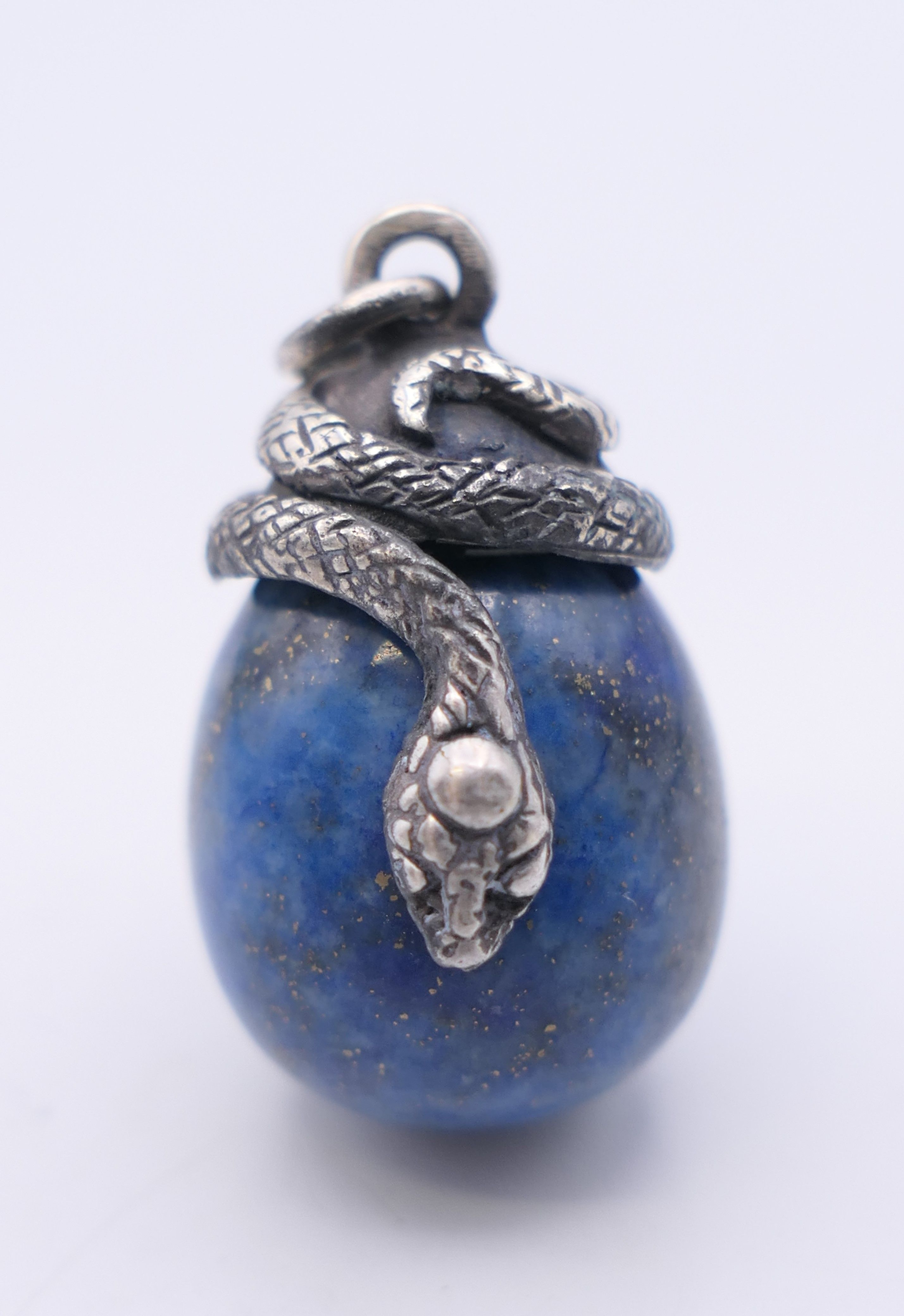 A lapis egg form pendant surmounted with a snake, bearing Russian marks. 2.5 cm high.