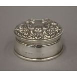 A silver box with repousse decoration to the lid, hallmarked Birmingham 1982. 8.5 cm diameter.
