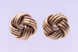 A pair of 9 ct gold diamond set earrings. 1 cm diameter. 7 grammes total weight.