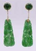 A pair of 18 ct gold carved jade earrings. 5.5 cm high.