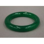 An apple green jade bangle. Approximately 6 cm interior diameter.