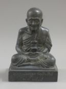A bronze model of a monk decorated with calligraphy. 19 cm high.
