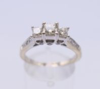 A 14 ct gold three stone diamond ring. Ring size P/Q. 3.7 grammes total weight.