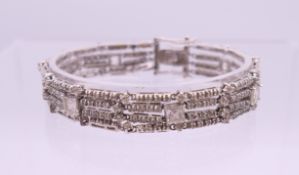 A silver three strand paste set bracelet. 18 cm long.