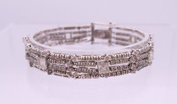 A silver three strand paste set bracelet. 18 cm long.