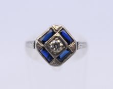 An 18 ct white gold Deco style diamond and sapphire ring. Ring size K/L. 2.9 grammes total weight.