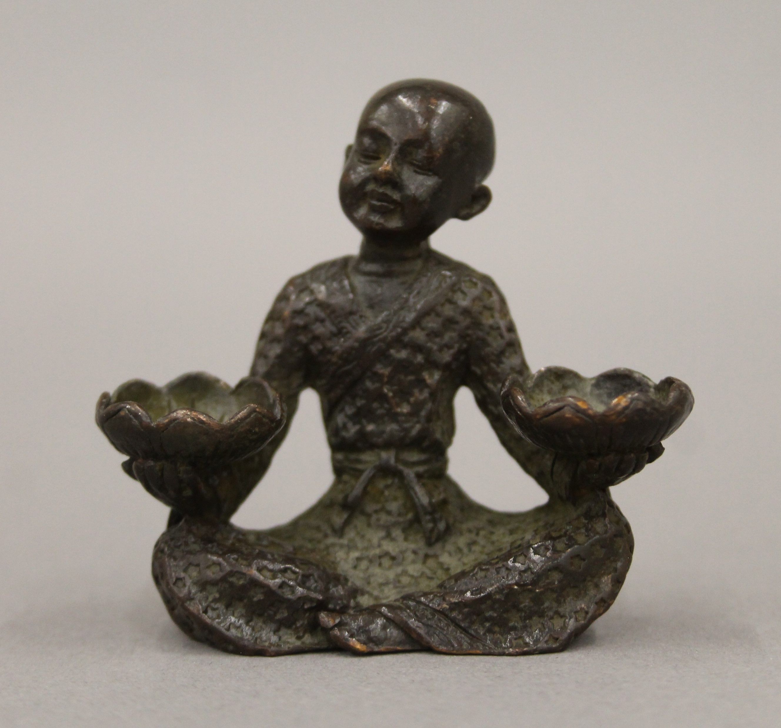 A bronze model of a boy with lilies. 5.5 cm high.