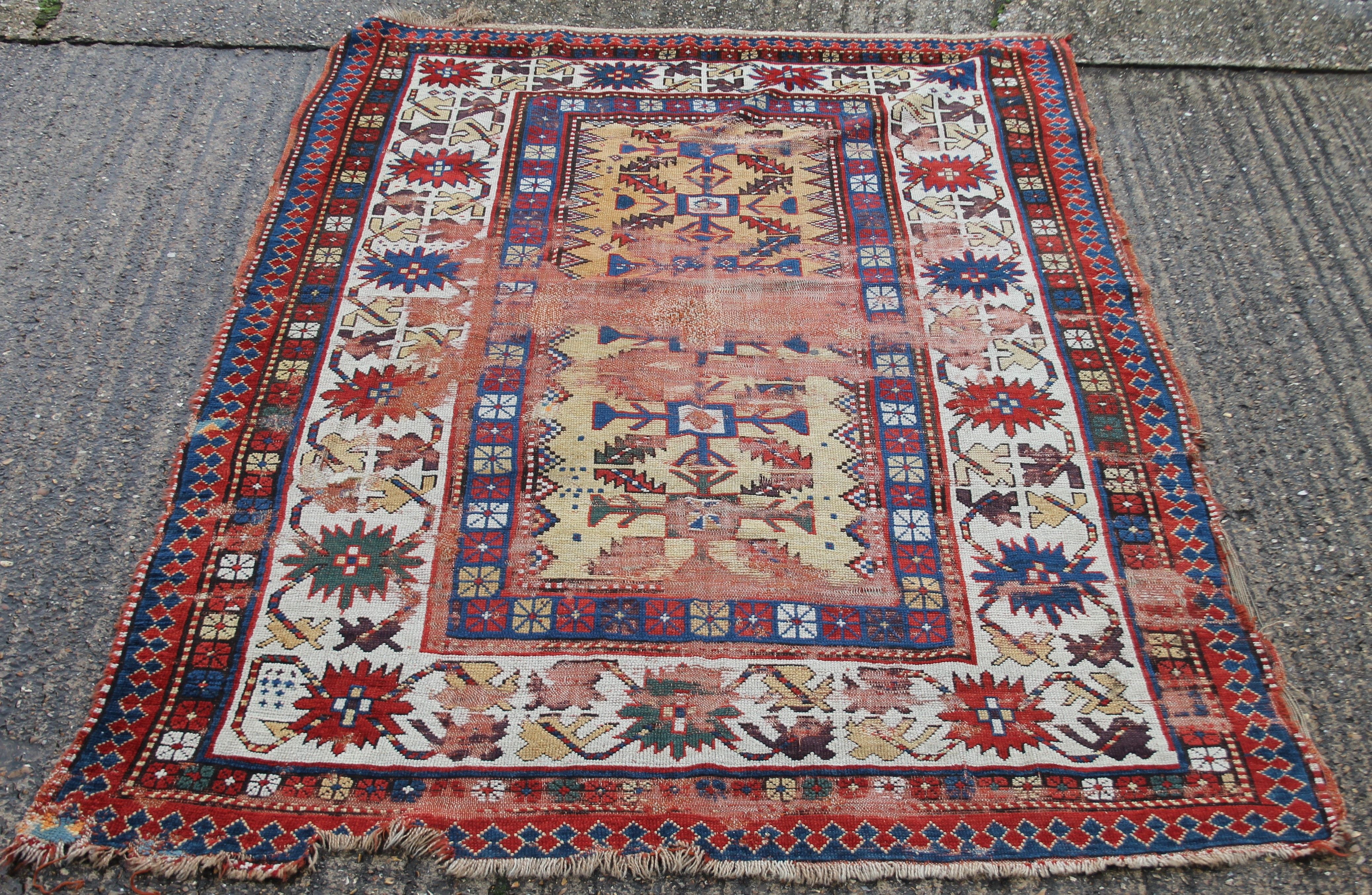 A Caucasian red ground wool rug. 142 x 220 cm.