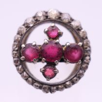 An unmarked gold, diamond and ruby ring. Size L/M. 4.3 grammes total weight.