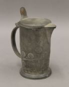 A Liberty and Co Tudric pewter jug. 16 cm high.