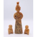 A Chinese jade standing male figure, together with two smaller kneeling male figures, Han Dynasty.