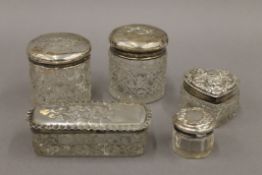 Five silver topped dressing table jars. The largest 9 cm long.