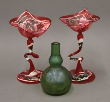 A Loetz type glass vase and two red ground glass vases (one damaged). The former 11 cm high.