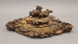 A Blackforest wooden ink stand carved with hares. 37 cm wide.