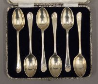 A cased set of silver teaspoons with golf club decoration. 80.1 grammes.