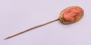 An unmarked gold coral mounted stick pin. 7 cm long. 4.2 grammes total weight.