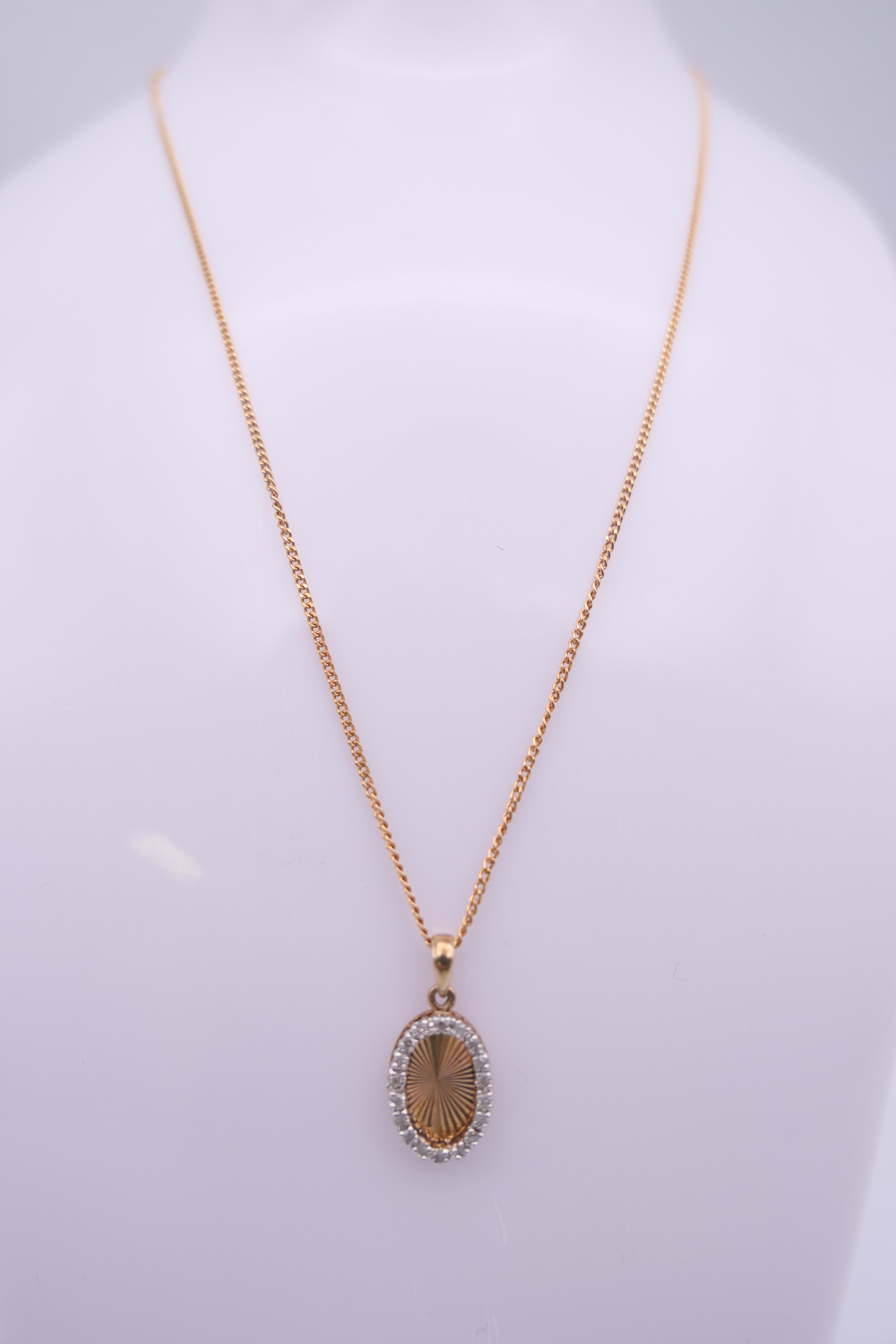 A 9 ct gold and diamond oval pendant on a 9 ct gold chain. Pendant 1. - Image 2 of 10