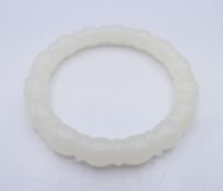 A carved white jade bangle. Approximately 5.5 interior diameter.