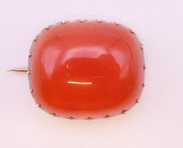 A Victorian gold brooch set with carnelian. 2.5 cm x 2 cm. 7.9 grammes total weight.