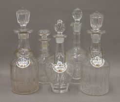 Five various cut glass decanters, three bearing Crown Staffordshire spirit labels.