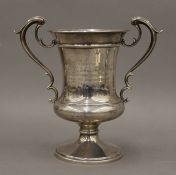 A silver twin handled trophy cup inscribed 'Presented to Charles John Phillips Esq as a token of