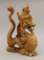 An early 20th century Eastern carved wooden dragon. 30 cm high.