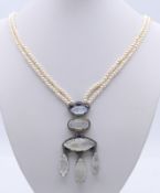 A diamond set pendant on two strand pearl necklace. Approximately 46 cm long.