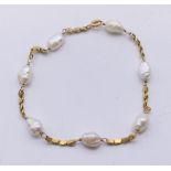 A 14 ct gold and pearl bracelet. 18.5 cm long.