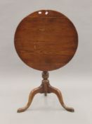 A 19th century oak and elm tilt top tripod table. 63 cm diameter.