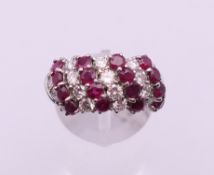 An 14 ct white gold ruby and diamond dress ring. Ring size K/L. 8.7 grammes total weight.