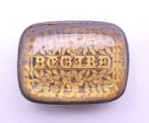 An unmarked vinaigrette with stone set top, the grill inscribed 'Regard'. 3 cm x 2.25 cm.