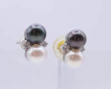 A pair of white gold black and white cultured pearl and diamond earrings. 1.5 cm wide.
