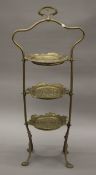 An Art Nouveau brass three-tier cake stand. 82 cm high.