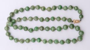 A small jade bead necklace with 14 ct gold clasp. 56 cm long.